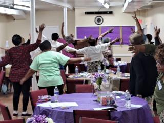 Older adult women exercising at health education seminar.