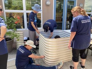 Volunteers assembling raised garden beds.