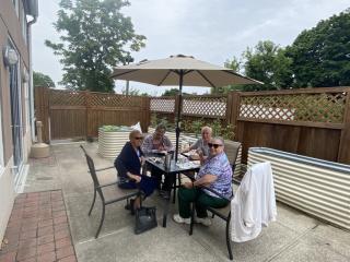 Older adults eating lunch in the garden patio.