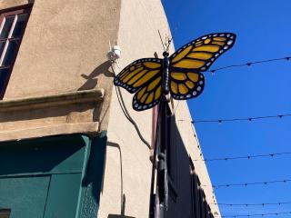 Monarch butterfly sculpture at entrance to alley.